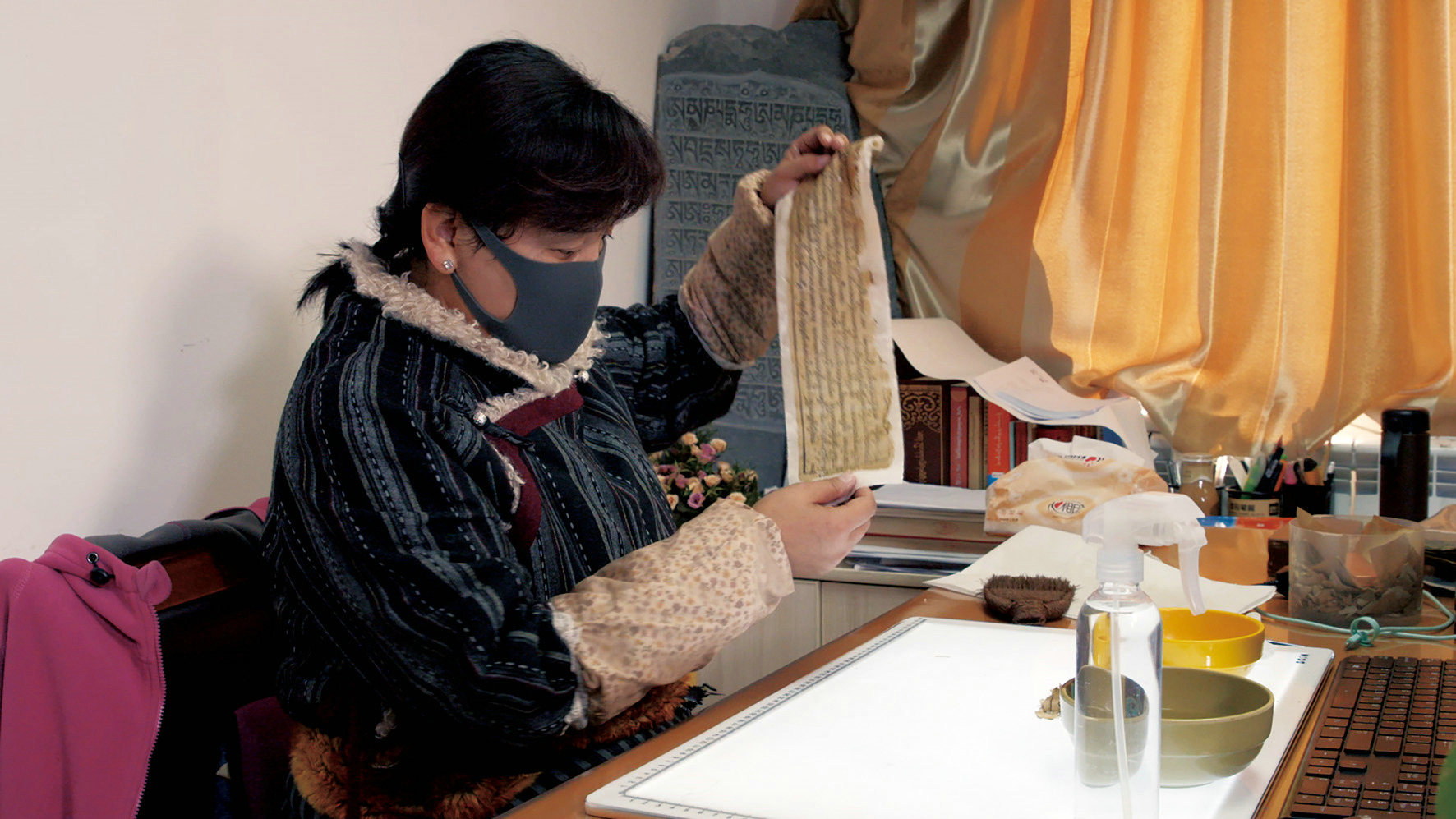 西藏自治区图书馆的古籍修复师央拉正在修复藏文古籍.jpg